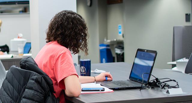 一个学生在考尔斯图书馆用笔记本电脑工作的照片